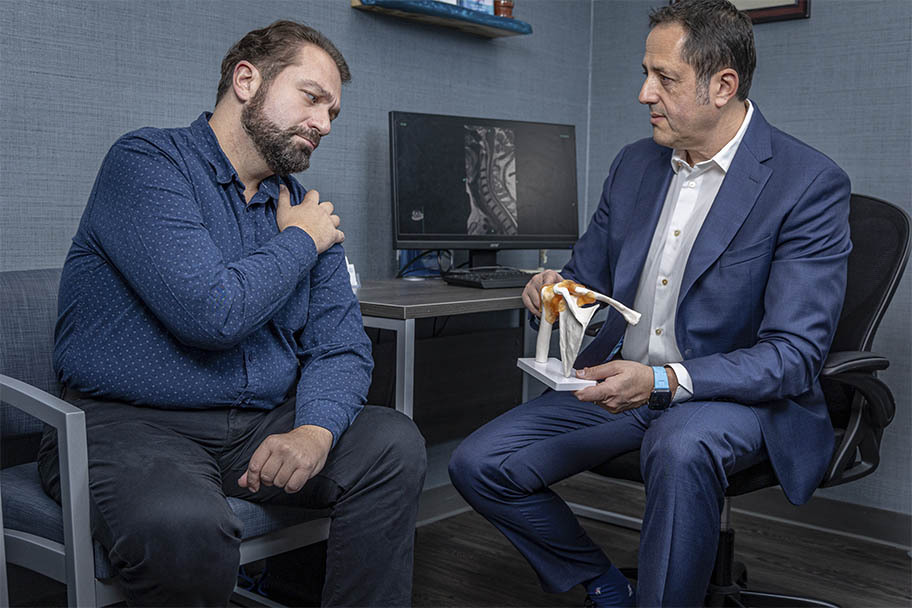 Shoulder impingement consultation at Pain Management NYC with specialist explaining shoulder anatomy and treatment options.